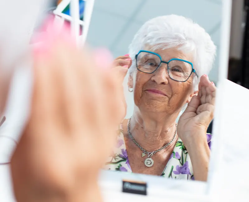 Kundin probiert eine neue Brille vor dem Spiegel